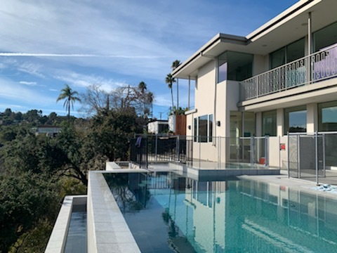 Pool on the side of a two story building.