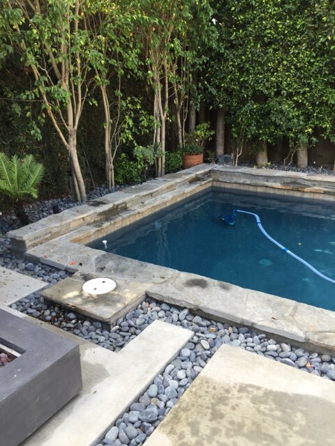 Pool with an outdoor fireplace on the side.