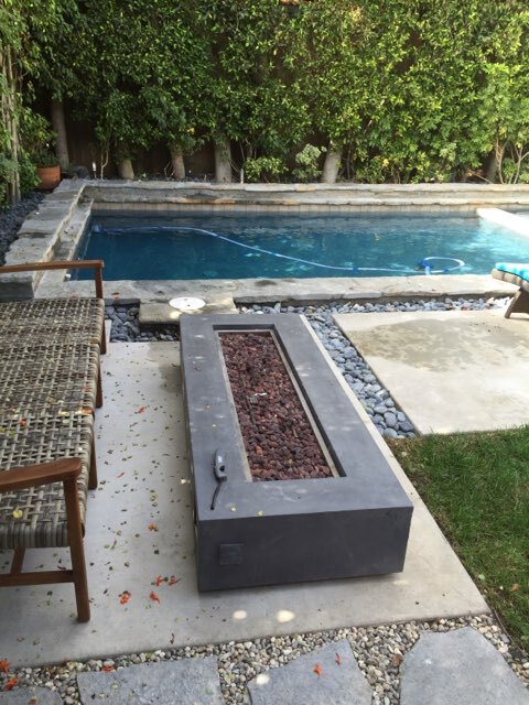 Pool with an outdoor fireplace by the side.