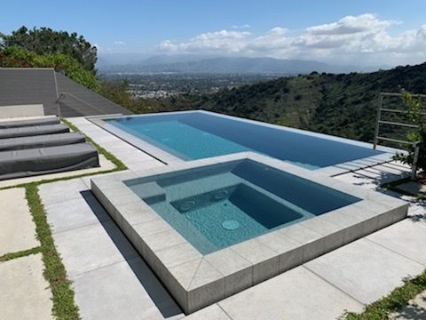 Pool with a jacuzzi with a view of the mountains.