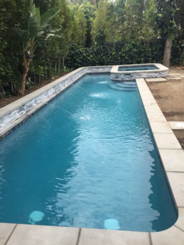 A long pool with a raised jacuzzi.