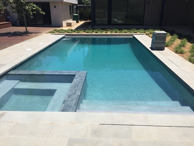 A pool with a jacuzzi built in.